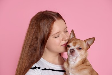 Photo of Teenage girl with her cute Chihuahua dog on pink background, closeup