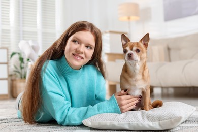 Photo of Teenage girl with her cute Chihuahua dog at home