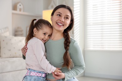 Photo of Family portrait of beautiful mother with little daughter at home. Space for text