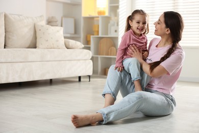 Photo of Happy mother with little daughter spending time together at home. Space for text