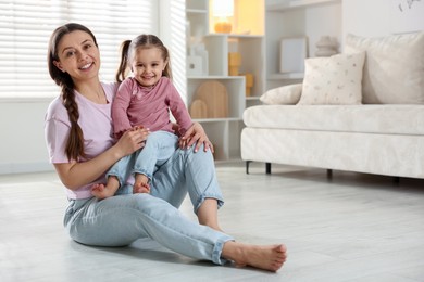 Photo of Happy mother with little daughter spending time together at home. Space for text