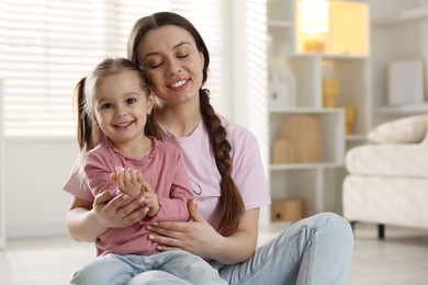 Photo of Family portrait of beautiful mother with little daughter at home. Space for text