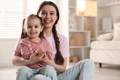 Photo of Family portrait of beautiful mother with little daughter at home. Space for text