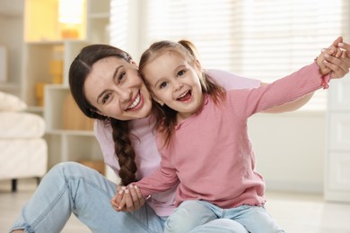 Photo of Family portrait of beautiful mother with little daughter at home