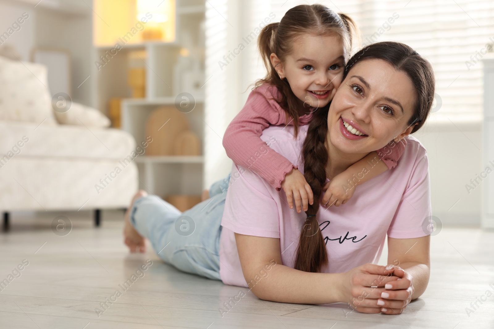 Photo of Happy mother with her little daughter spending time together at home. Space for text