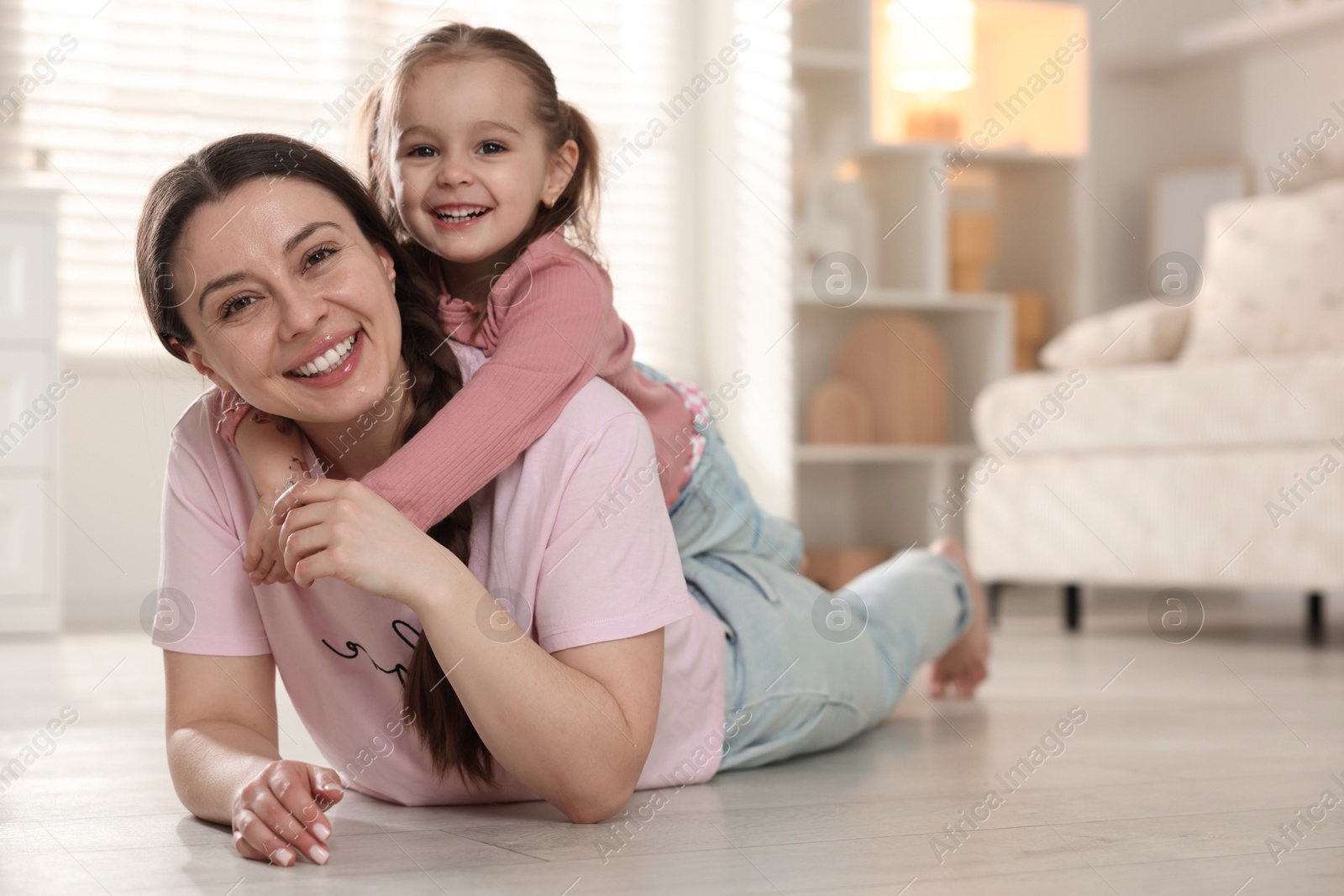 Photo of Happy mother with her little daughter spending time together at home. Space for text