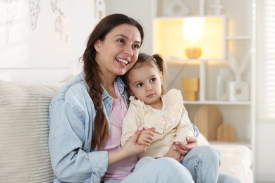 Photo of Happy mother with her cute little daughter on sofa at home