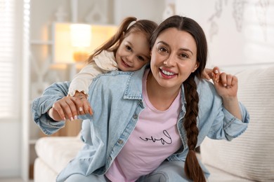 Photo of Portrait of happy mother and her cute daughter at home