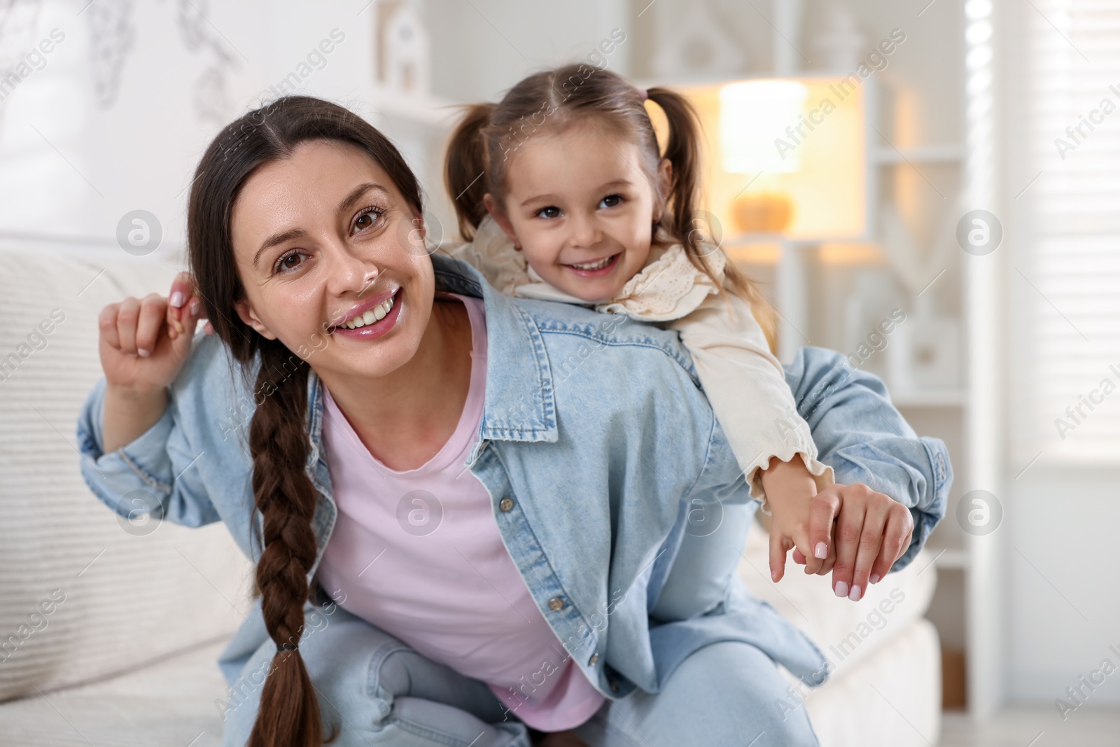 Photo of Portrait of happy mother and her cute daughter at home