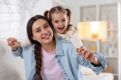 Photo of Portrait of happy mother and her cute daughter at home