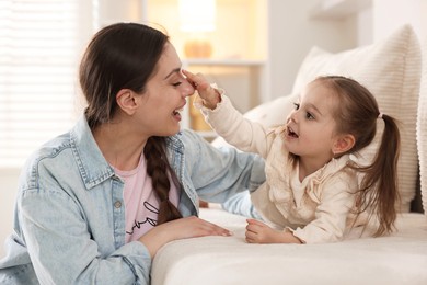 Photo of Happy mother with her cute daughter spending time together at home