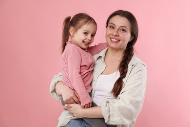 Photo of Portrait of happy mother with her cute daughter on pink background