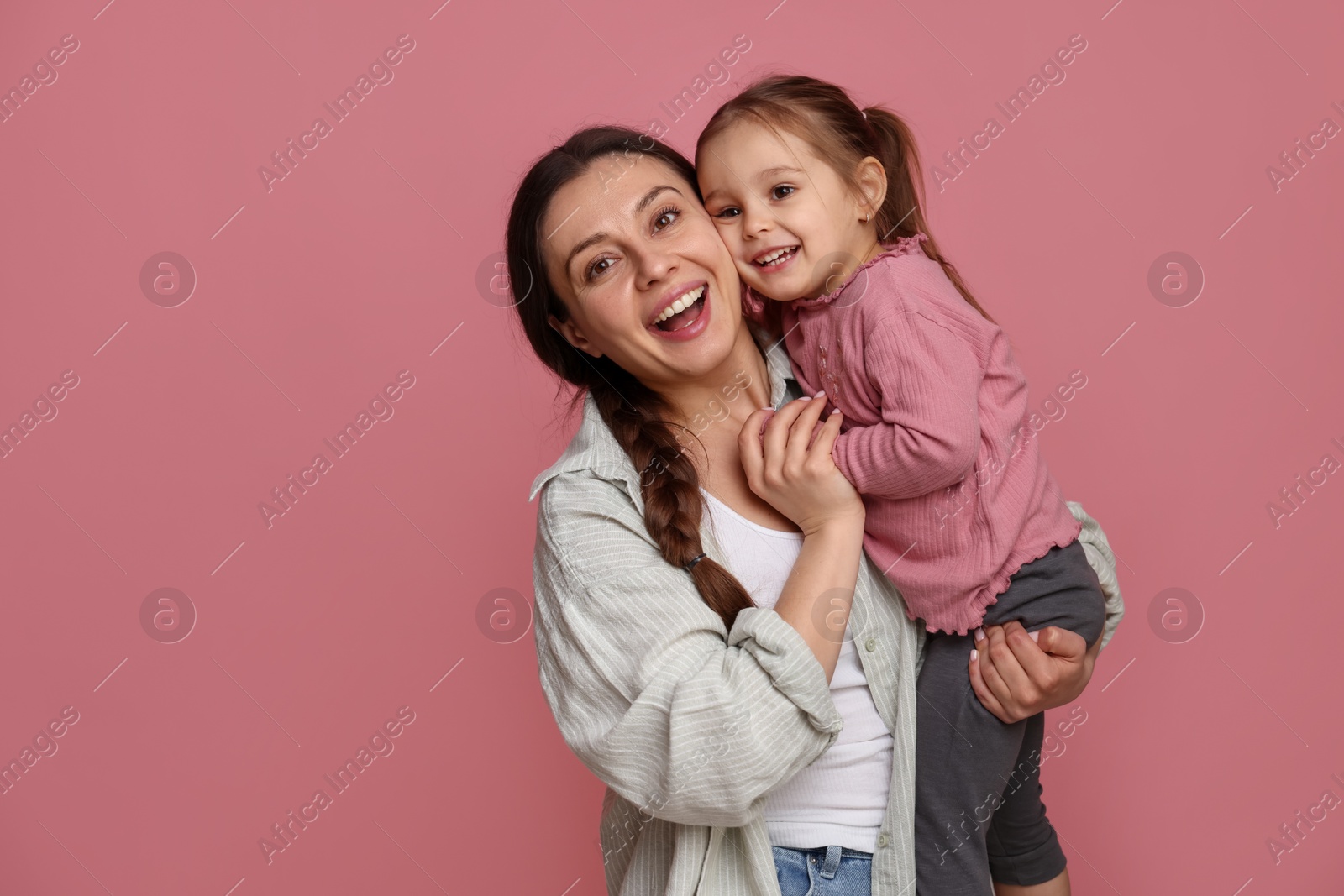 Photo of Portrait of happy mother and her cute daughter on pink background. Space for text