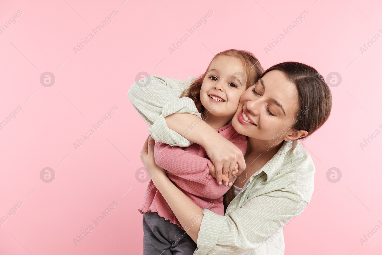 Photo of Portrait of happy mother and her cute daughter on pink background. Space for text