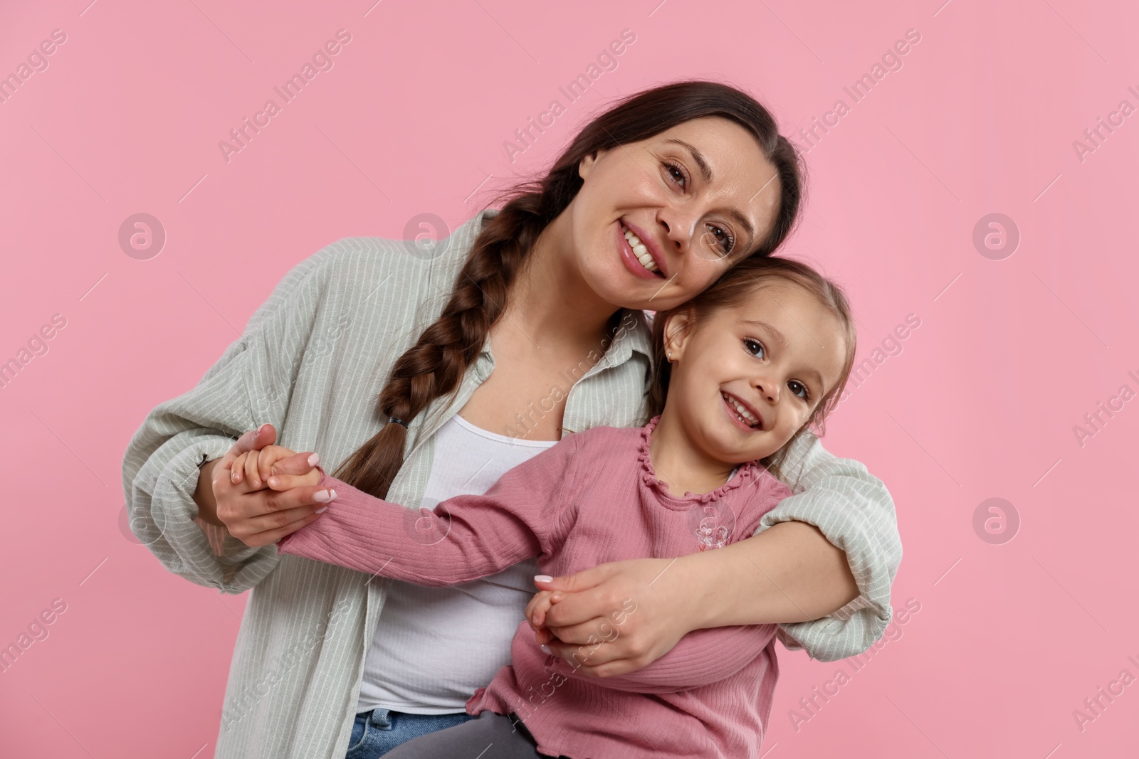 Photo of Family portrait of beautiful mother with little daughter on pink background