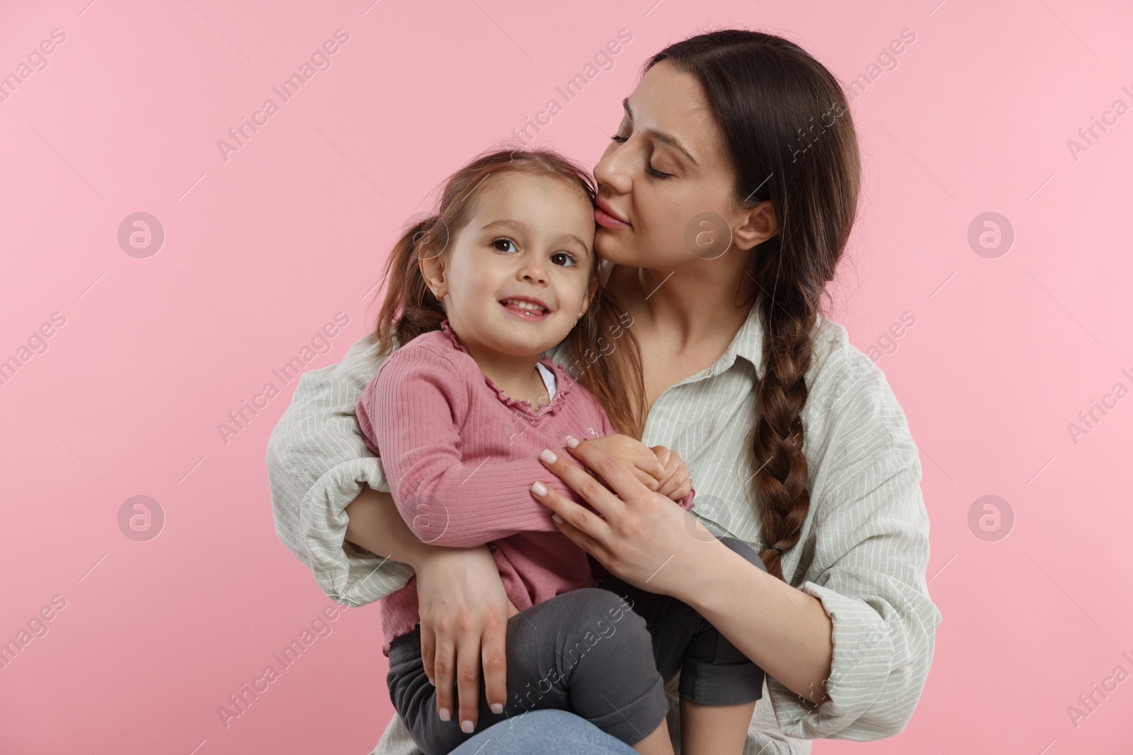 Photo of Portrait of mother with her cute daughter on pink background