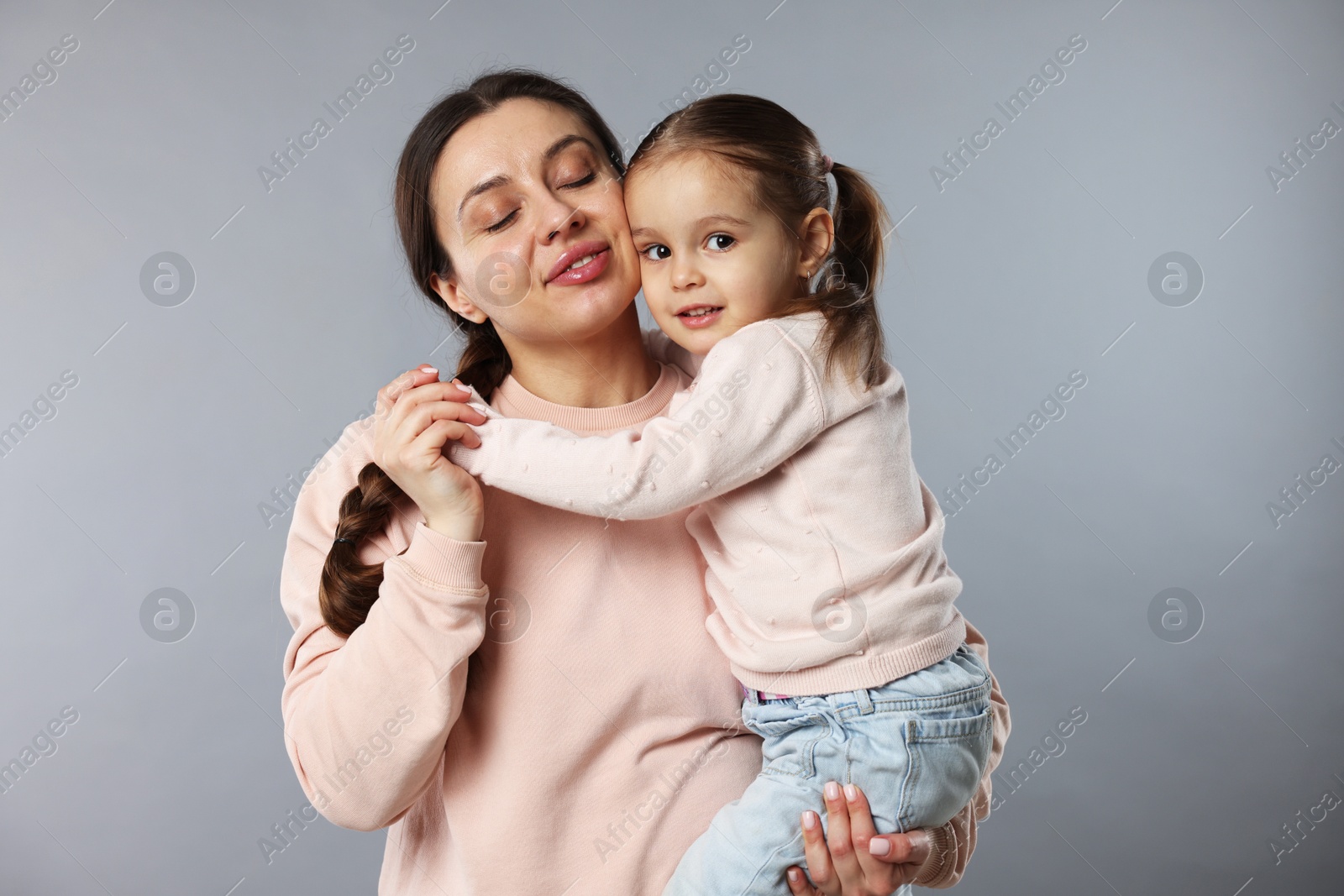 Photo of Family portrait of mother with cute little daughter on grey background