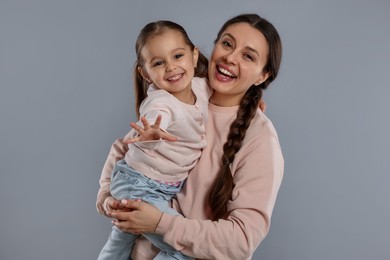 Photo of Family portrait of happy mother with little daughter on grey background