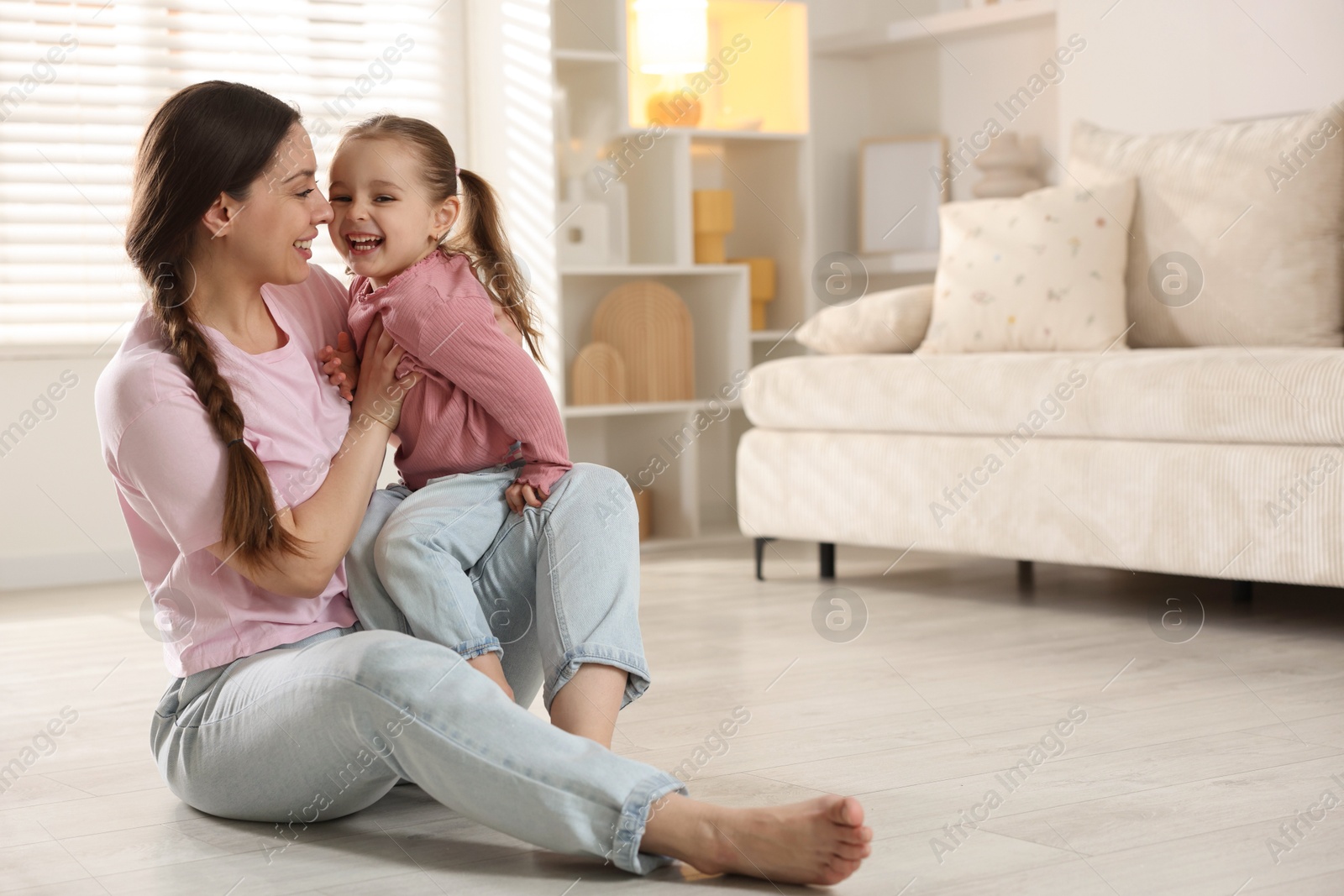 Photo of Happy mother with her little daughter spending time together at home. Space for text