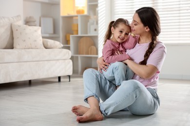 Photo of Happy mother with her little daughter spending time together at home. Space for text