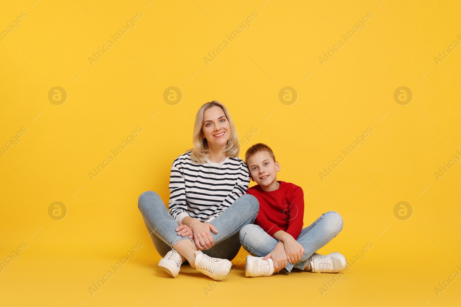 Photo of Happy mother and son on orange background