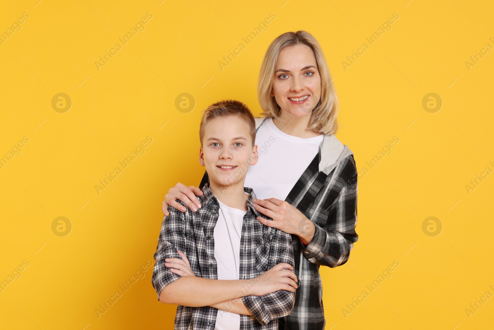 Photo of Happy mother and son on orange background