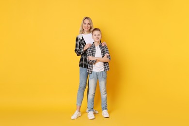 Photo of Happy mother and son on orange background