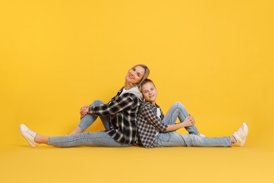 Photo of Happy mother and son on orange background