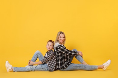 Photo of Happy mother and son on orange background