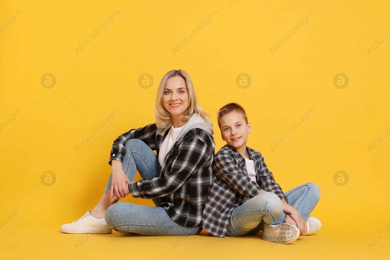 Photo of Happy mother and son on orange background