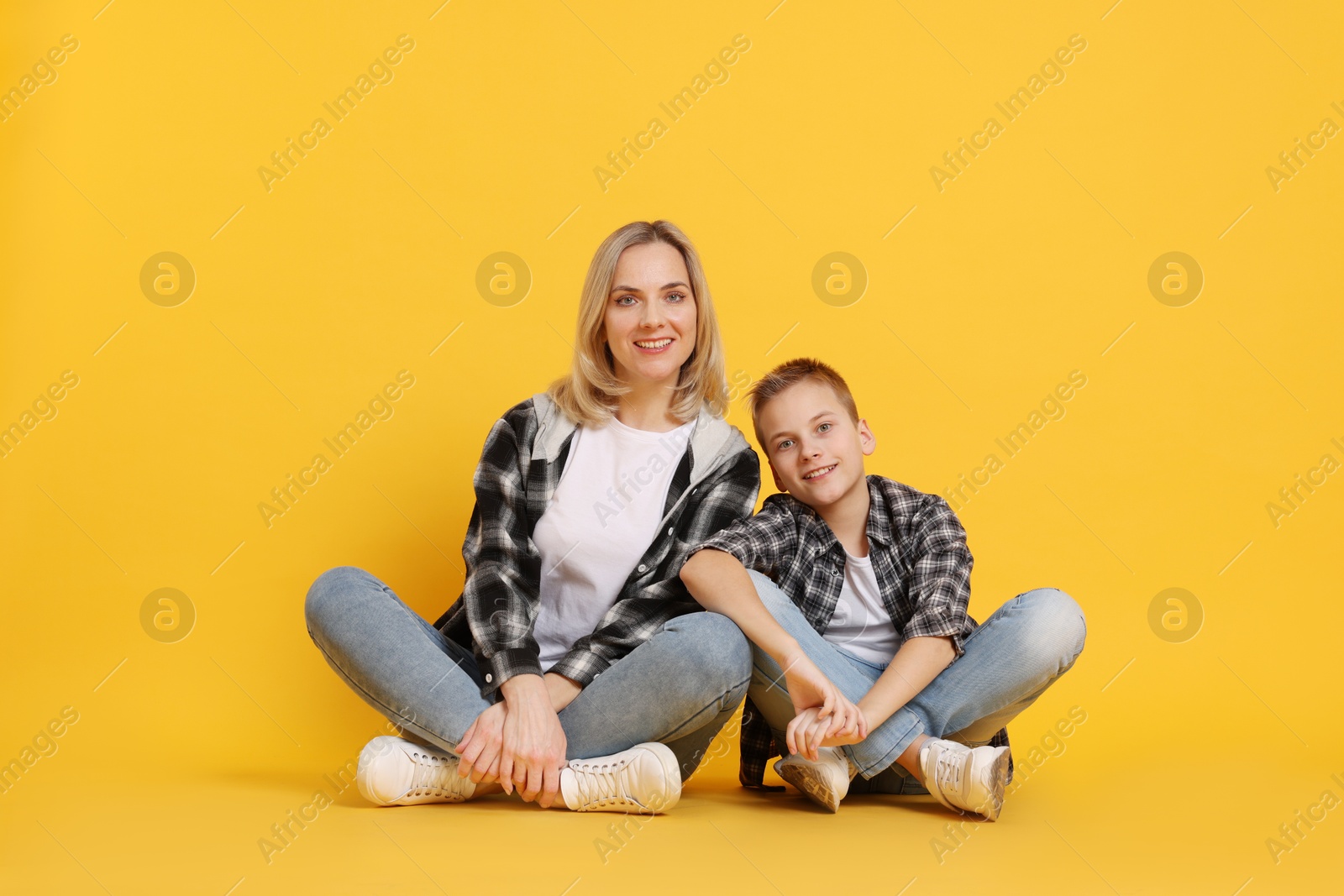 Photo of Happy mother and son on orange background