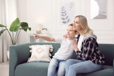 Photo of Son showing something to his mom at home