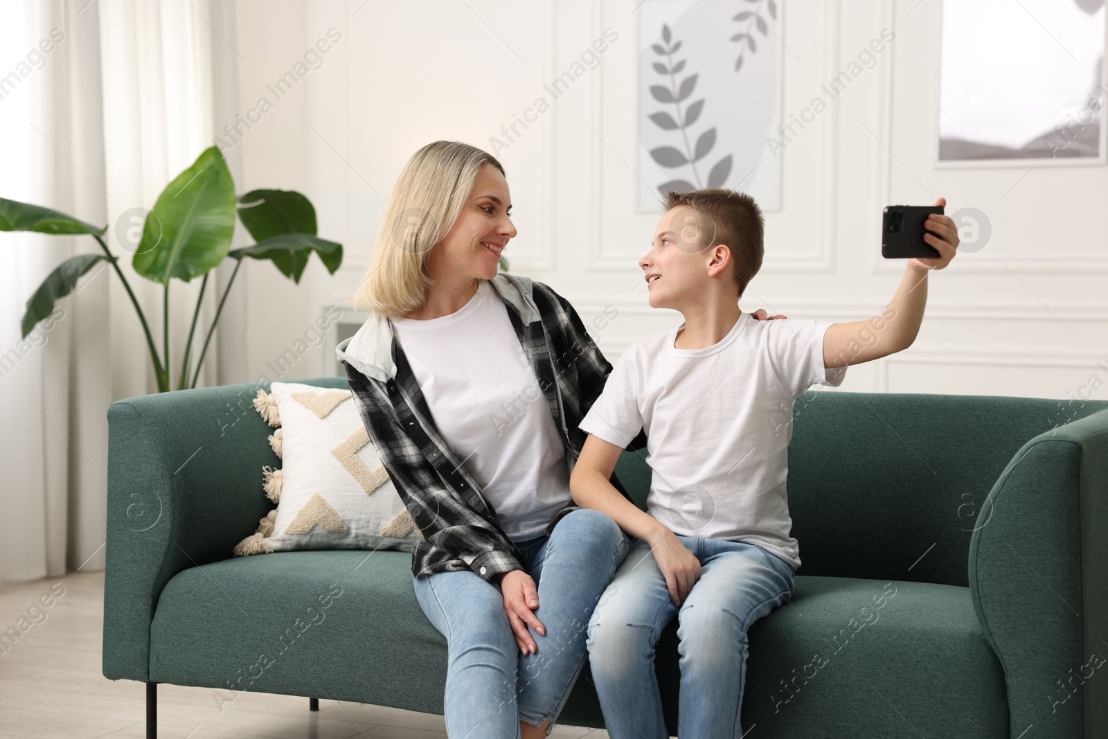 Photo of Mother and son taking selfie at home