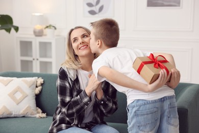 Photo of Son giving present to his mom at home