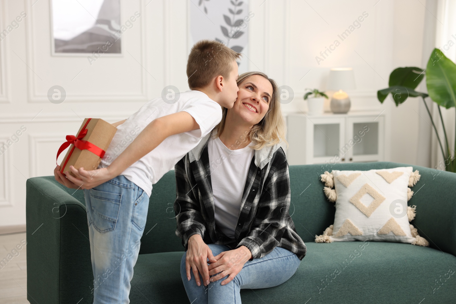 Photo of Son giving present to his mom at home