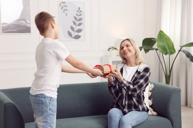 Photo of Son giving present to his mom at home