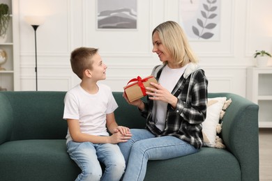 Photo of Son giving present to his mom at home