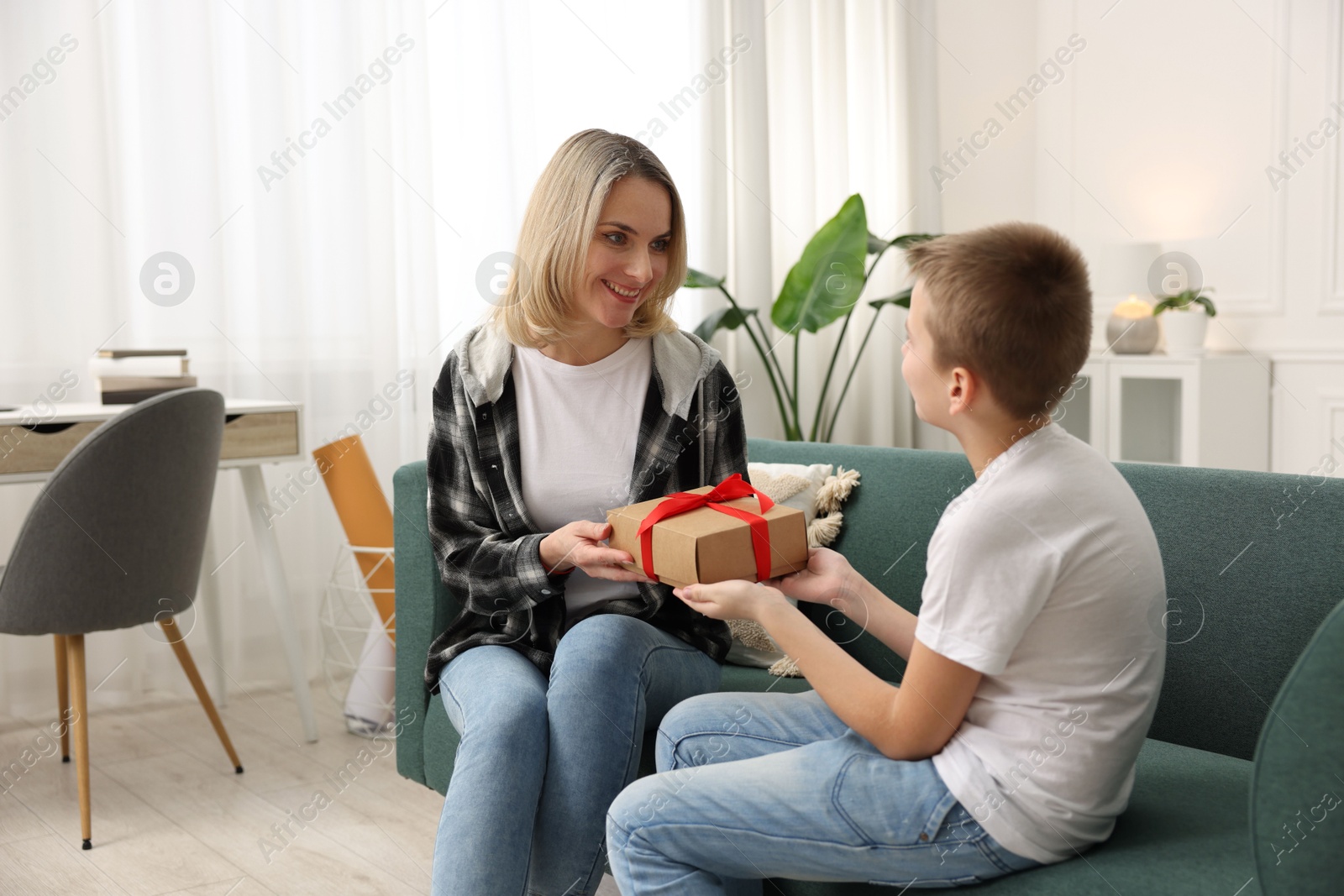 Photo of Son giving present to his mom at home