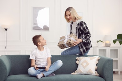 Photo of Mother giving present to her son at home