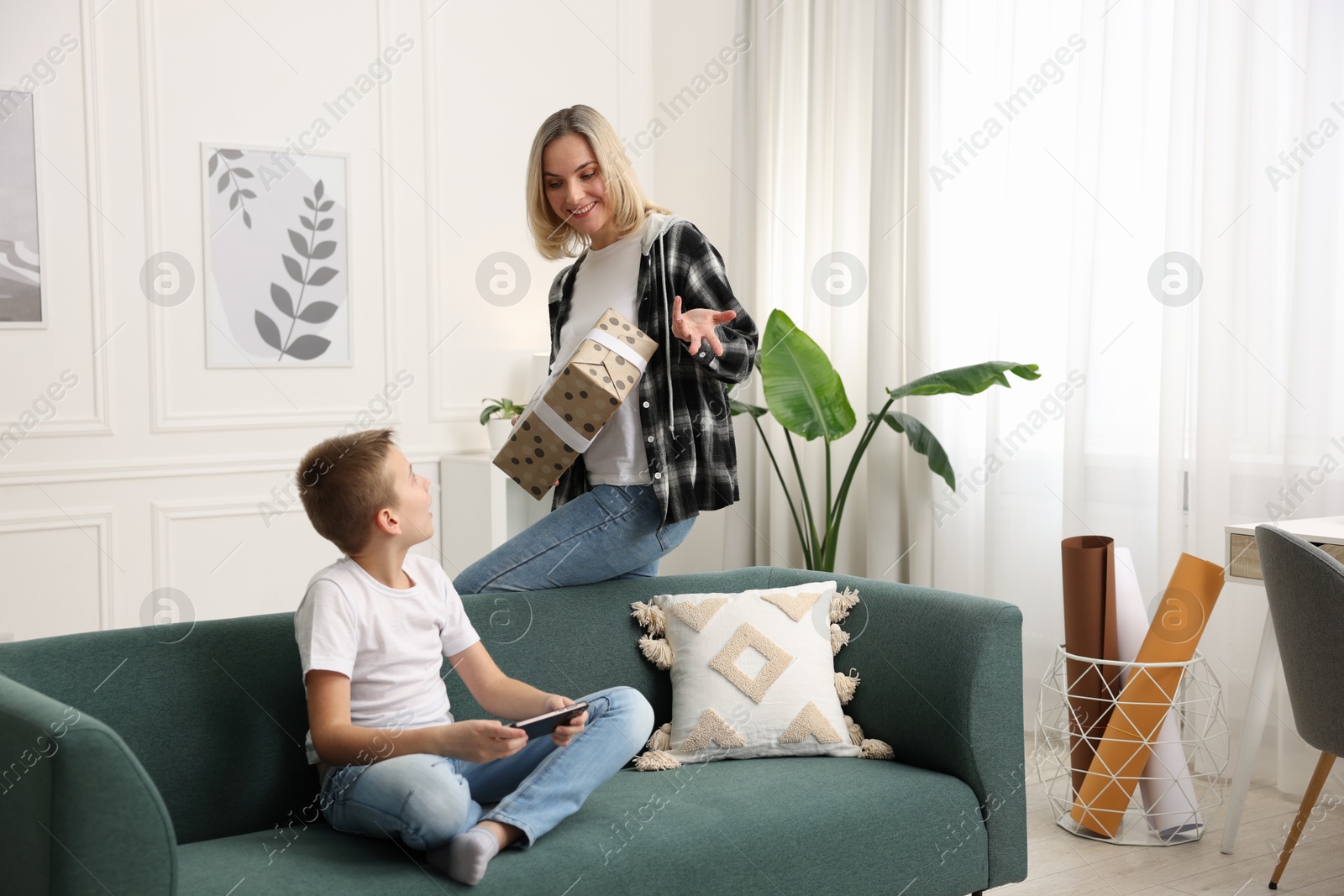 Photo of Mother giving present to her son at home