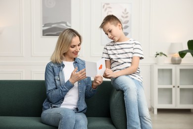 Photo of Son giving card to his mom at home