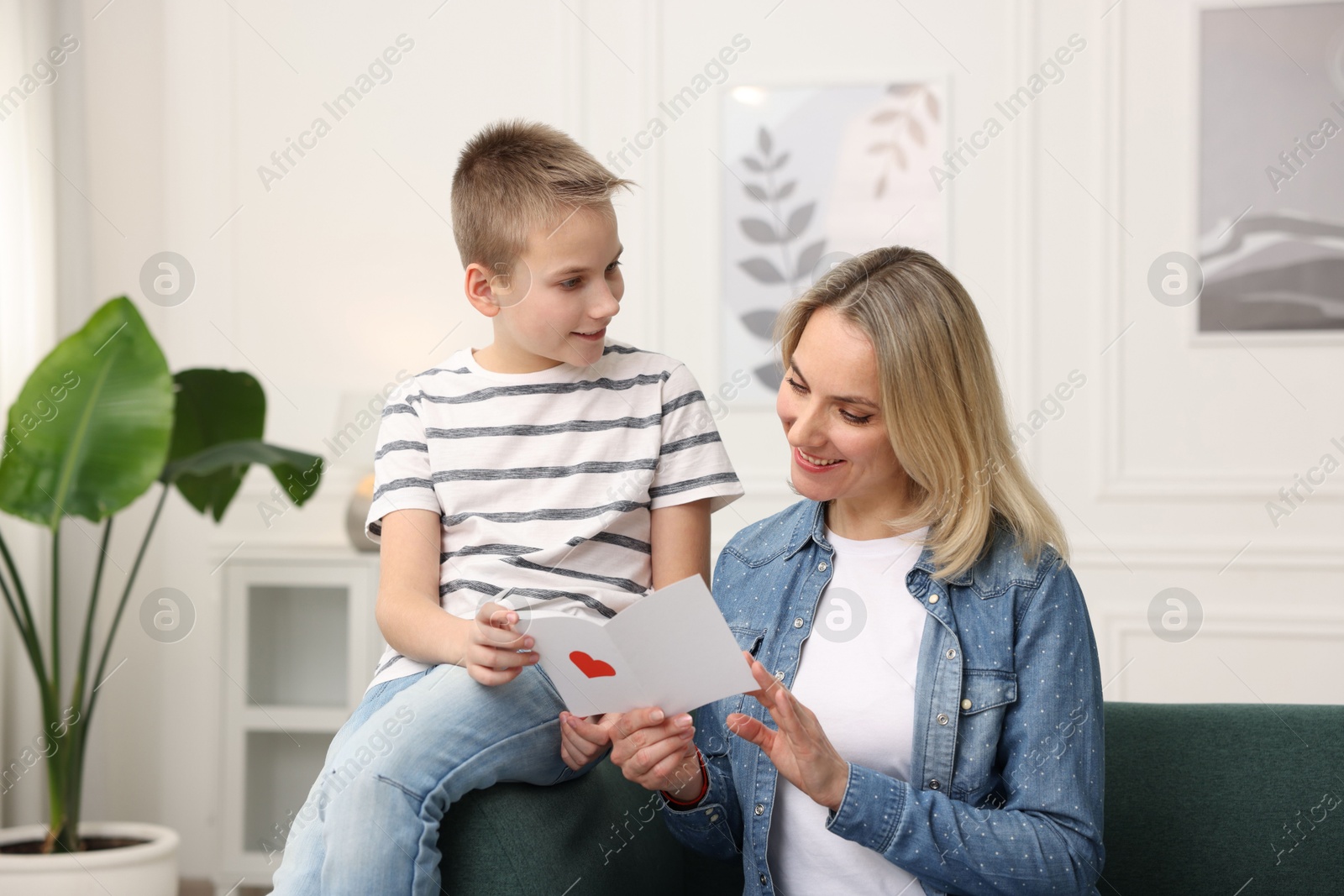 Photo of Son giving card to his mom at home