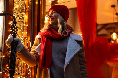 Photo of Portrait of happy woman near shop outdoors. Christmas season