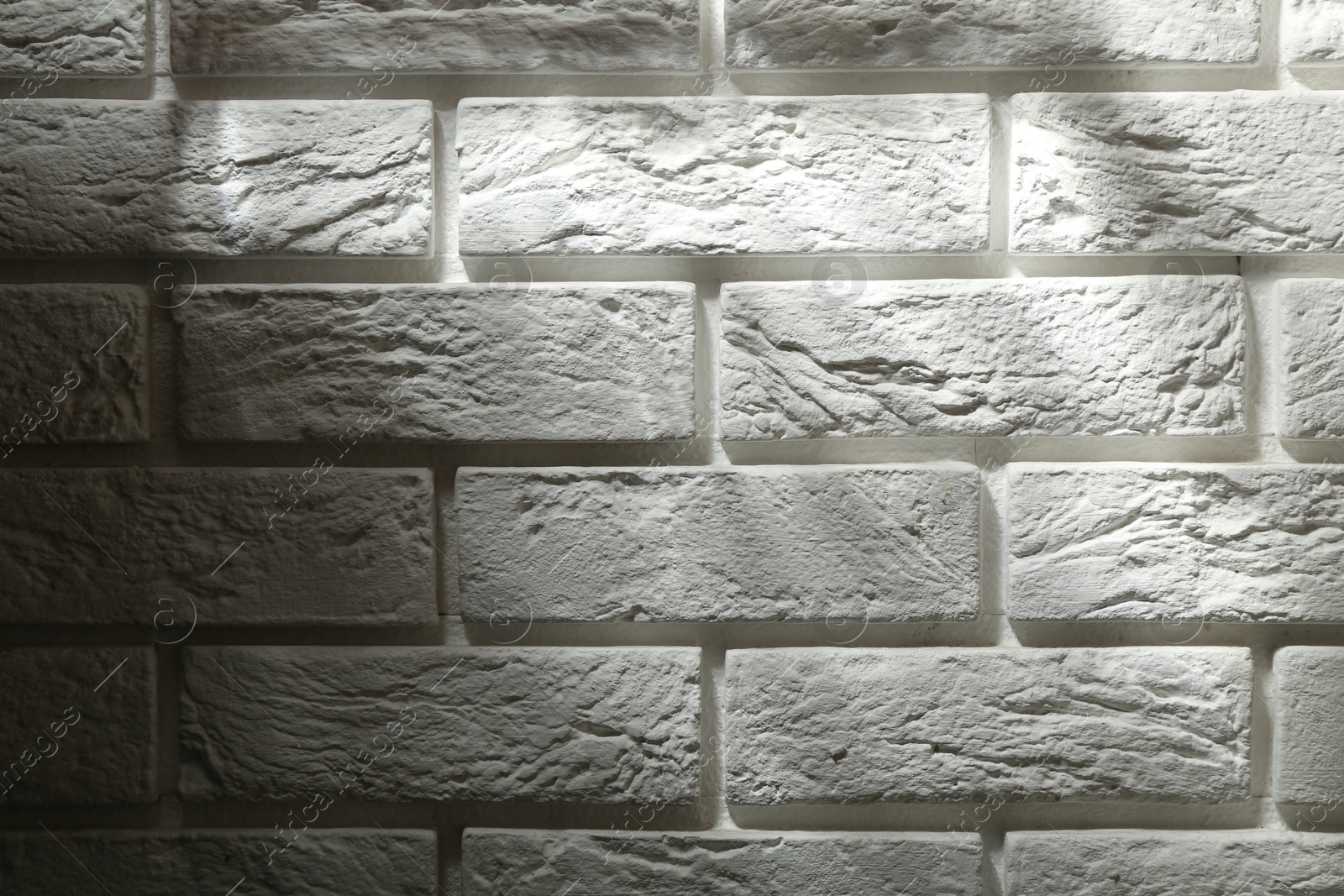 Photo of Light and shadows falling on white brick wall