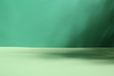 Photo of Light and shadows falling on green background