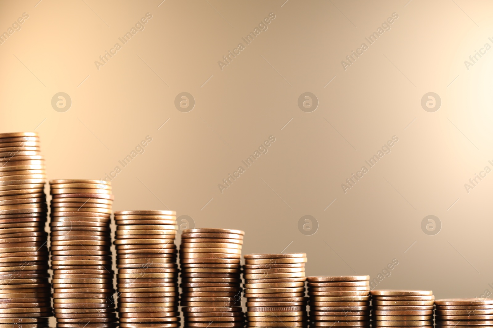 Stacks of coins on beige background, closeup. Space for text Photo of Stacks of coins on beige background, closeup. Space for text