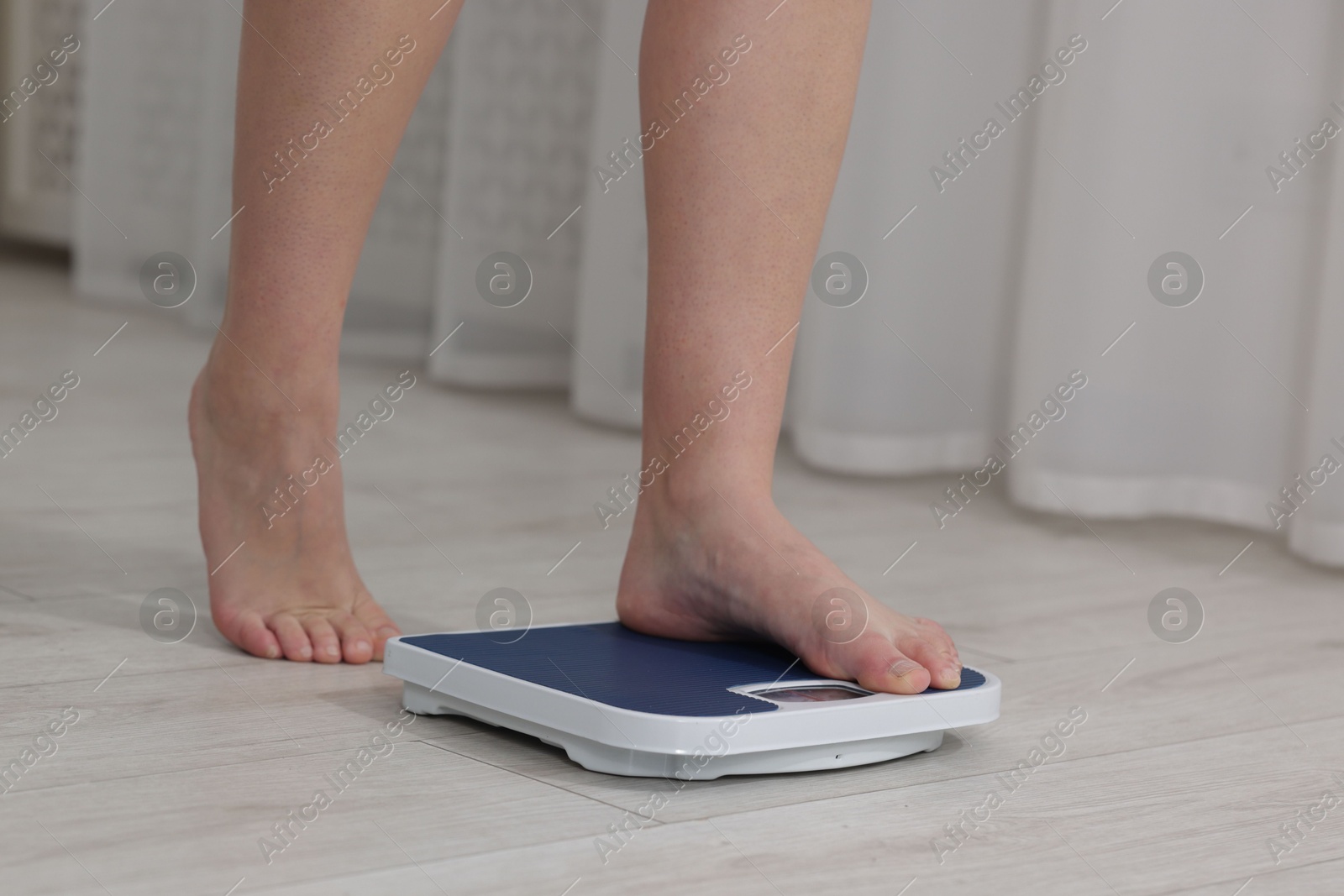 Photo of Woman on scales indoors, closeup. Weight loss