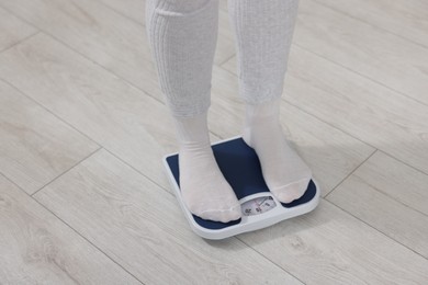 Photo of Woman on scales indoors, closeup. Weight loss