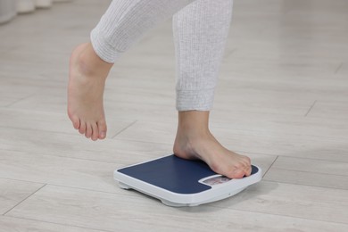 Photo of Woman on scales indoors, closeup. Weight loss