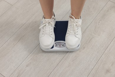 Photo of Woman on scales indoors, closeup. Weight loss